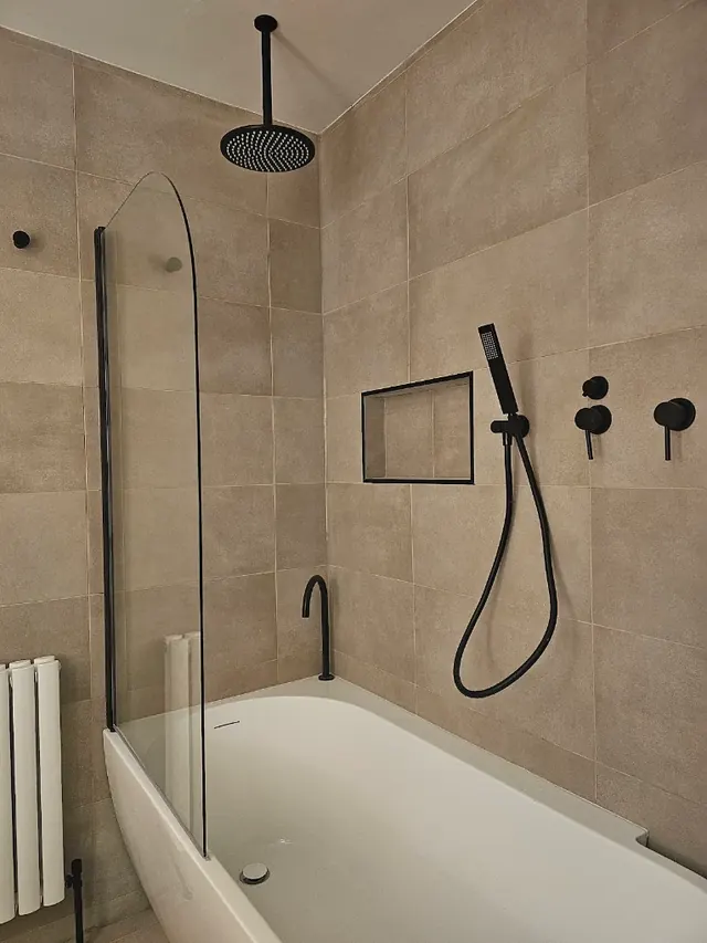 Bath with a ceiling-mounted rainfall shower, hand shower and concealed valves, all in matt black