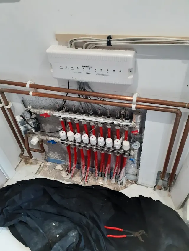 Heatmiser wiring centre linking each underfloor heating zone to its own thermostat, above the manifold