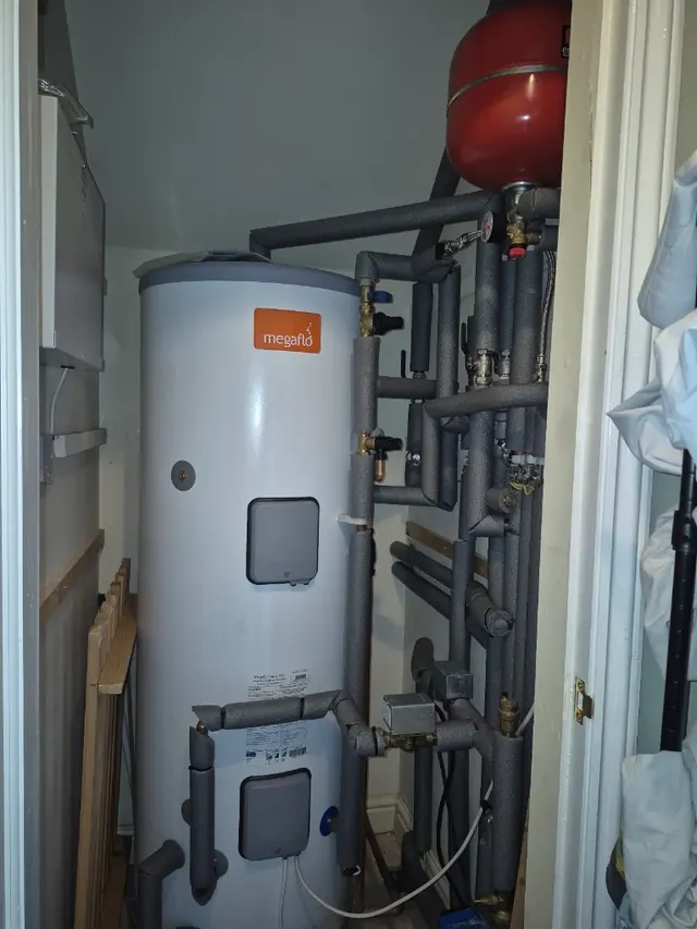 Megaflo unvented cylinder in an airing cupboard, with the pipework insulated