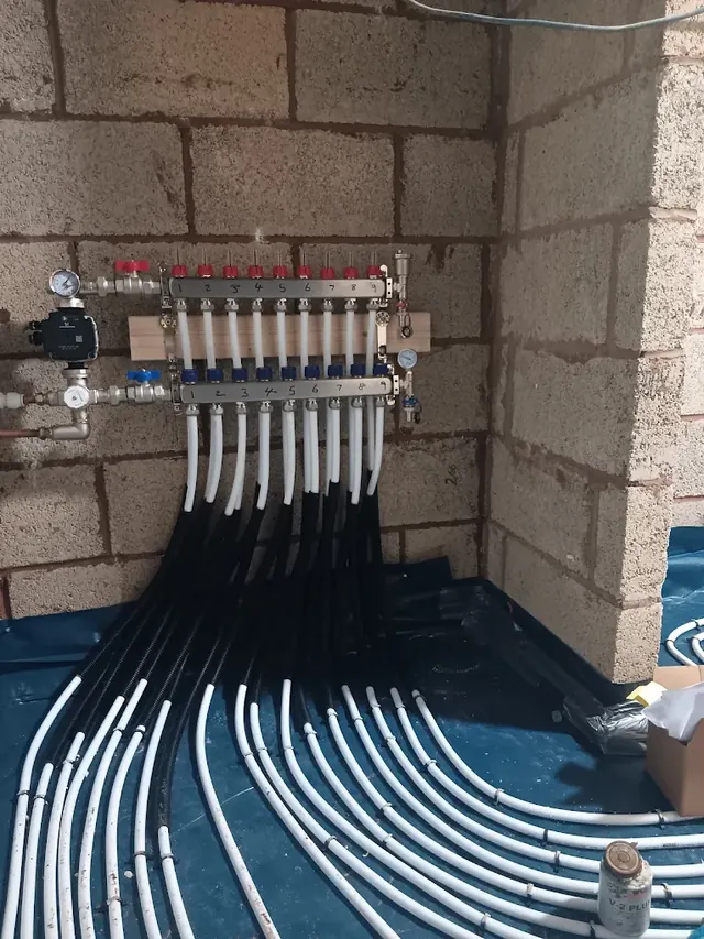 Underfloor heating manifold with its pump and numbered loops, one for each area of floor