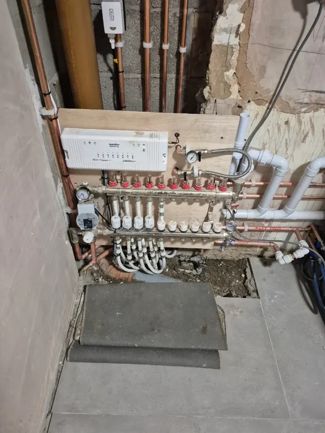 Underfloor heating manifold and pump, with a Heatmiser wiring centre above it for the room thermostats