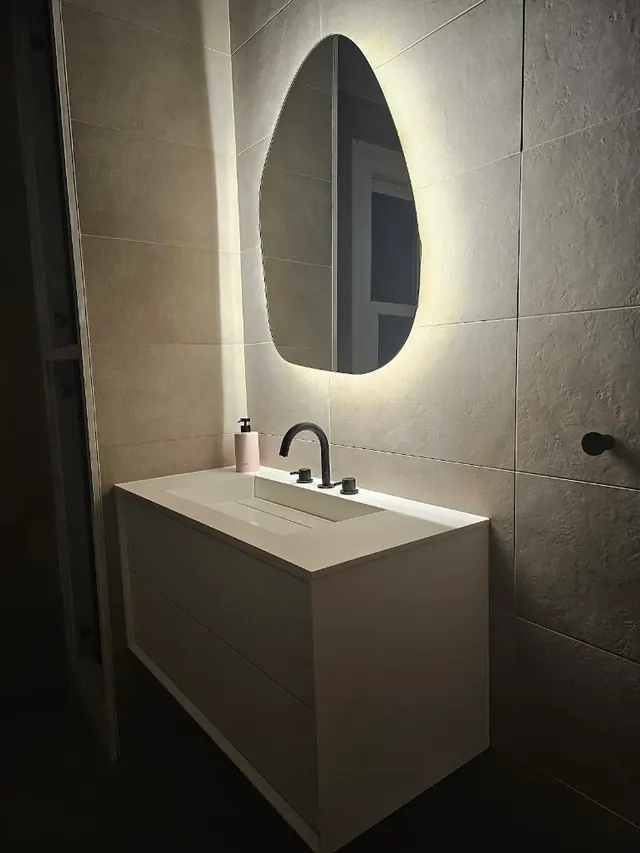 Wall-hung vanity unit with a matt black tap and a backlit mirror
